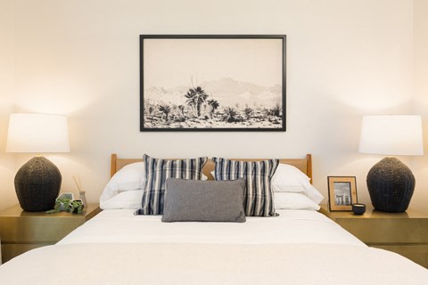 the master bedroom has a bed with white sheets and pillows