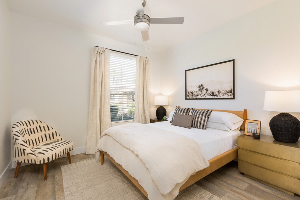 a bedroom with a bed and a chair and a ceiling fan