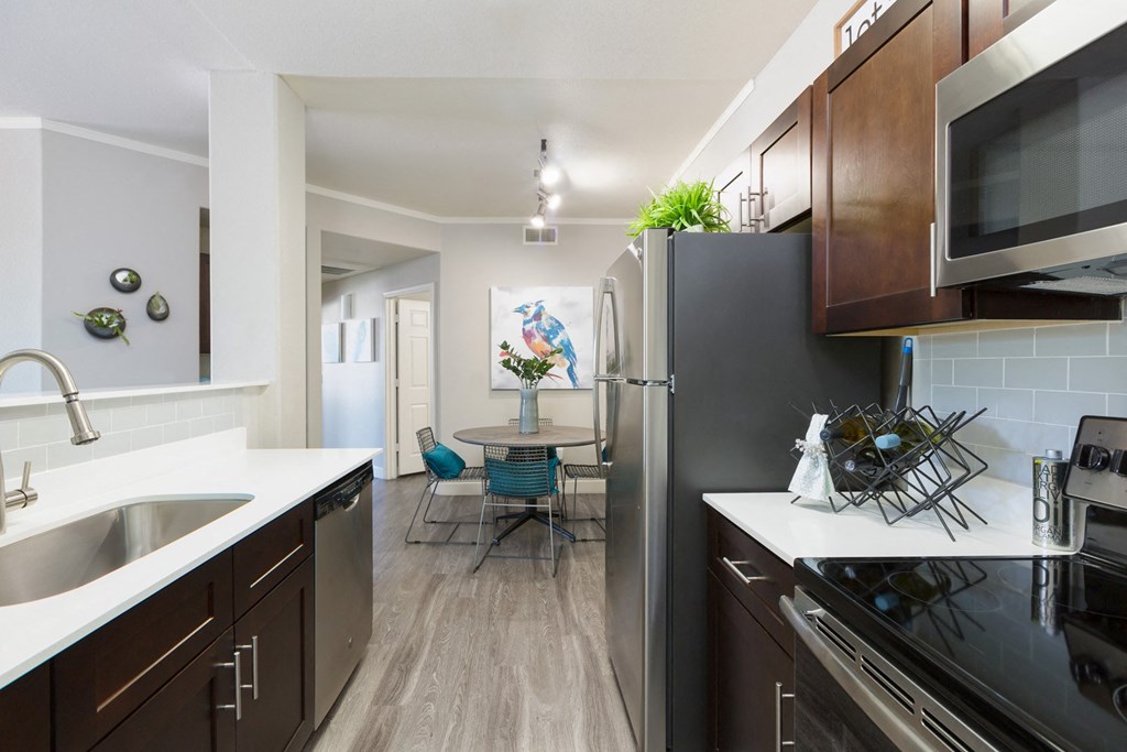 kitchen and dining room with stainless steel appliances at the district flats apartments