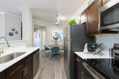 kitchen and dining room with stainless steel appliances at the district flats apartments
