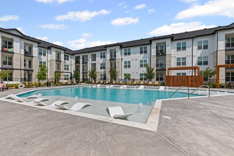A large swimming pool in front of apartment buildings.