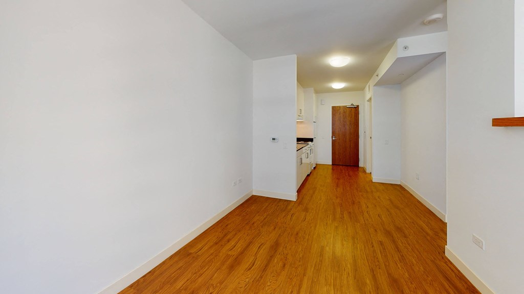 a bedroom with a medium hardwood floor and white walls