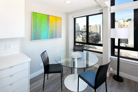 a dining room with a glass table and black chairs
