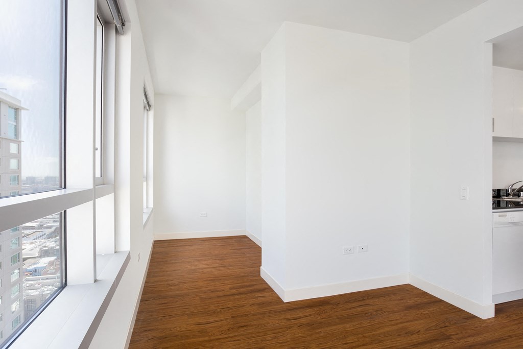 a bedroom with a medium hardwood floor and a large window