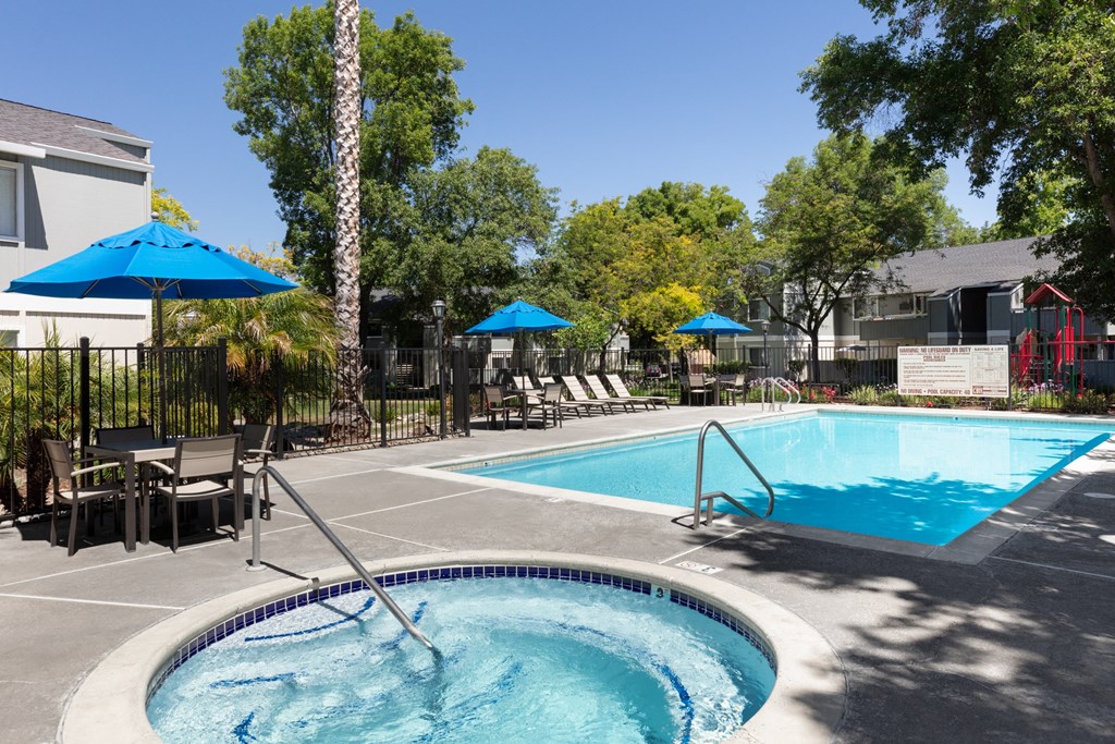 Apartments For Rent In Livermore, CA - Autumn Springs - Pool With Hot Tub, Tables, Chairs, Umbrellas, And Lounge Chairs