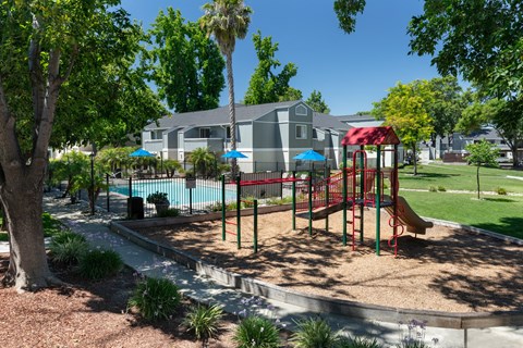 Children's Playground Adjacent To Pool And Grass Area