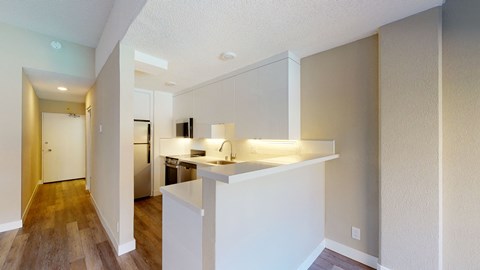 a kitchen with white cabinetry and hardwood floors