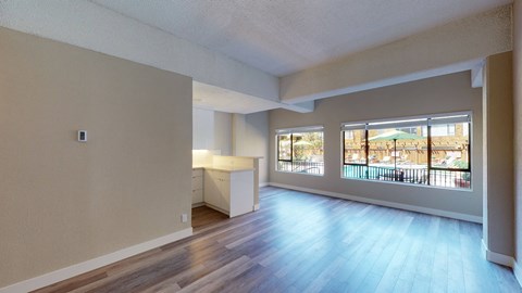 a spacious living room with a view of the pool at the oxford at estonia apartments
