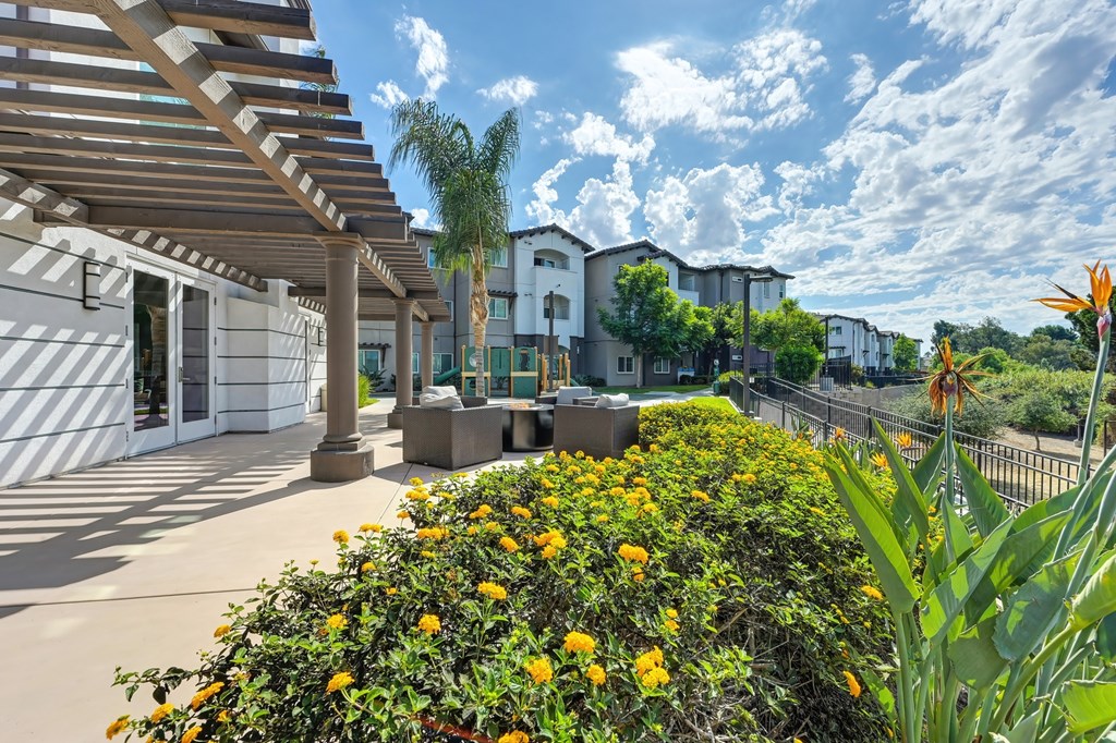 A sunny day at a residential area with apartment buildings and a fence.