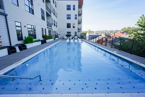 A swimming pool in a residential area with buildings in the background.