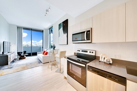 A modern kitchen with a stove top oven and microwave above it.