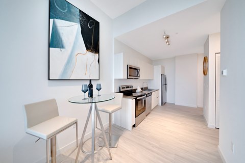 A modern kitchen with a glass table and chairs.