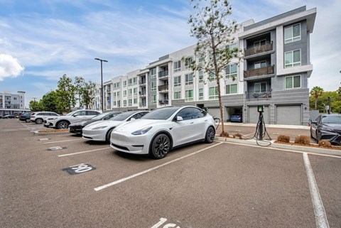 A parking lot with cars and a building in the background.