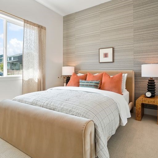 A bedroom with a large bed and a window with curtains.