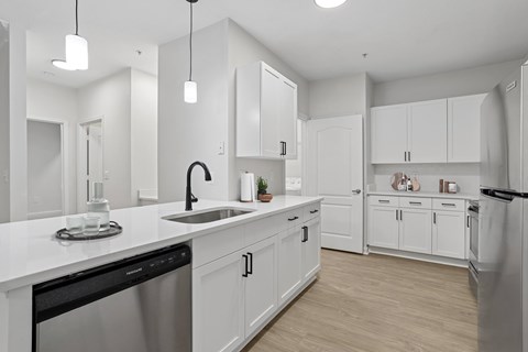 A modern kitchen with white cabinets and appliances.