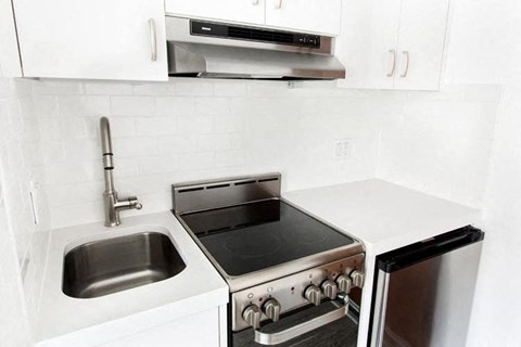 a kitchen with a stove top oven next to a sink