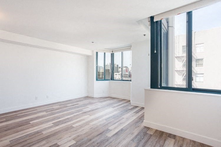 a bedroom with hardwood floors and a large window