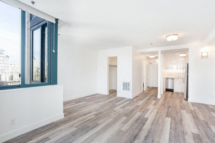 a bedroom with hardwood flooring and a large window