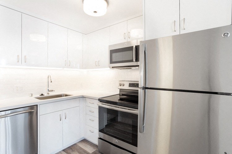 a kitchen with white cabinets and stainless steel appliances