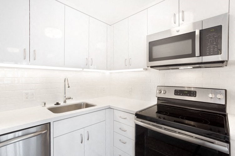 a kitchen with a stove top oven next to a sink