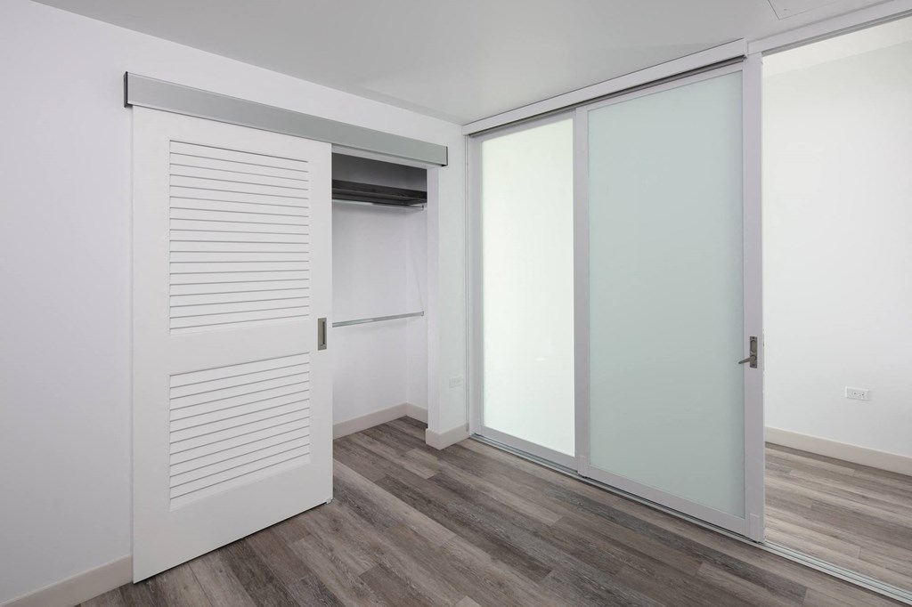a bedroom with white walls and a wooden floor