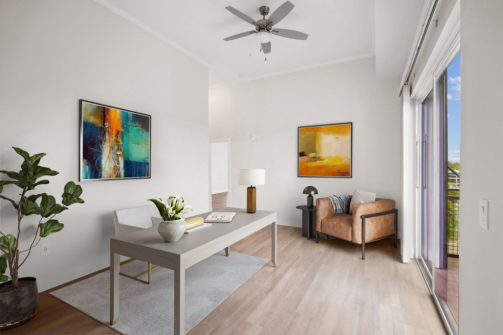 a living room with a ceiling fan and a table