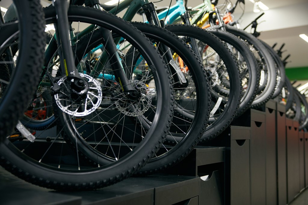 A row of bicycles are lined up on a shelf.
