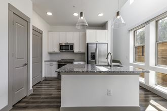a kitchen with white cabinets and a granite counter top