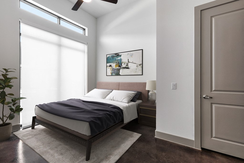 a bedroom with a bed and a large window