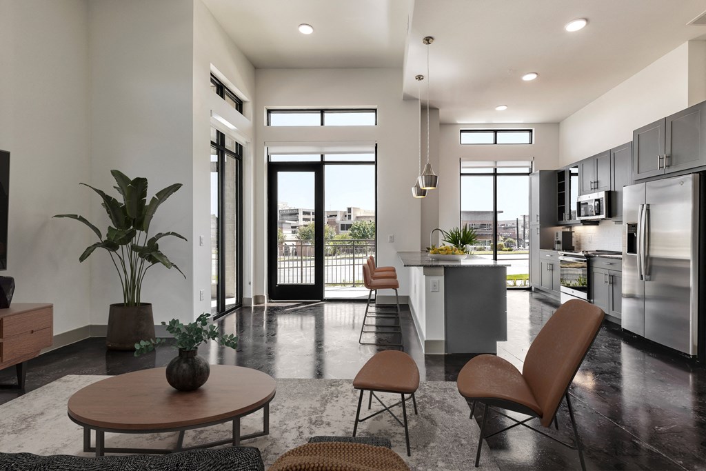 a kitchen and living room with stainless steel appliances and a table and chairs