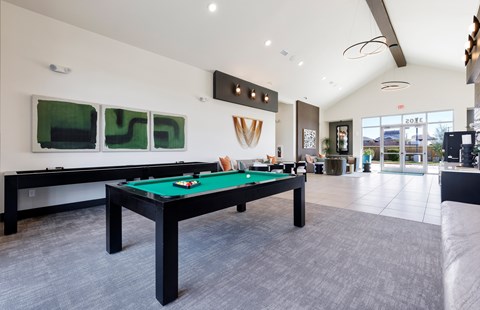 A pool table with green felt in a room with a white ceiling.