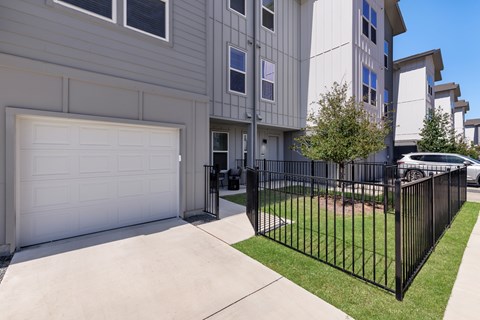 A black metal fence surrounds a white garage.