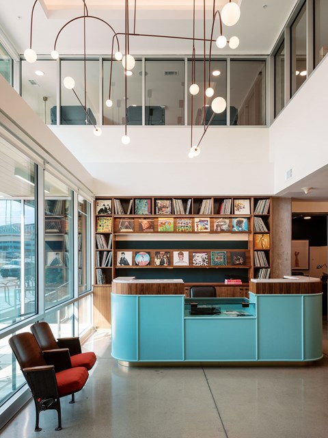 A reception area with a blue counter and red chairs.