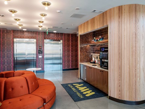 A reception area with a red sofa and a wooden counter.