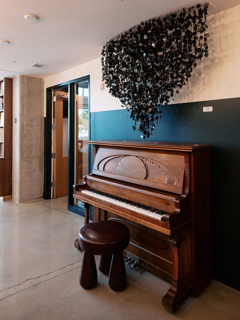 A brown piano with a brown stool in front of it.
