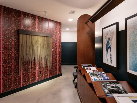 A hallway with a red and black patterned wallpaper and a wooden door.