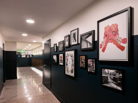 A hallway with a series of framed pictures on the wall.