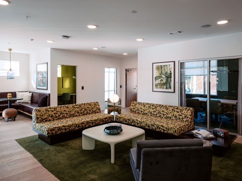 A living room with a green couch and a white coffee table.