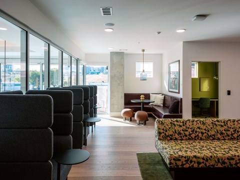 A long hallway with a row of chairs on the left and a couch on the right.