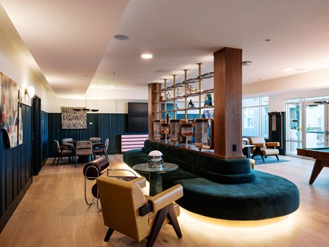 A modern living room with a yellow chair and a green ottoman.