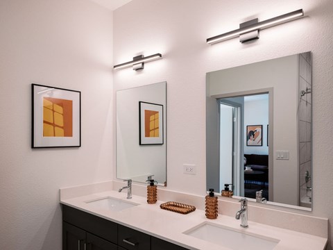 A bathroom with two sinks and a large mirror.