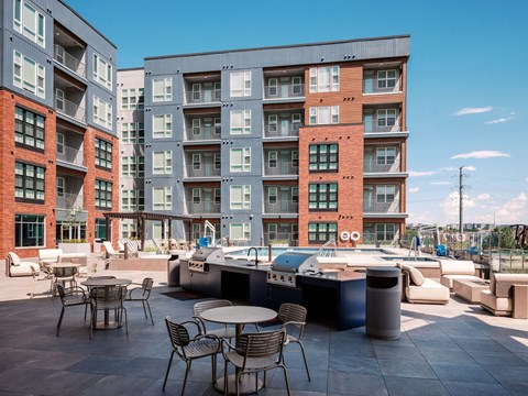 A modern apartment complex with a communal outdoor area featuring a hot tub.