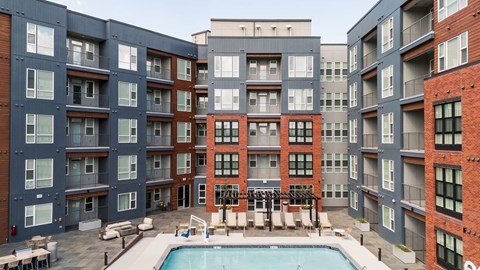 A large swimming pool is surrounded by apartment buildings.