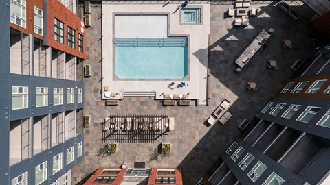 A view of a courtyard with a pool and a fence.