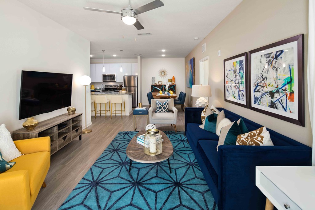 A living room with a yellow couch and a blue couch with a coffee table in the middle.