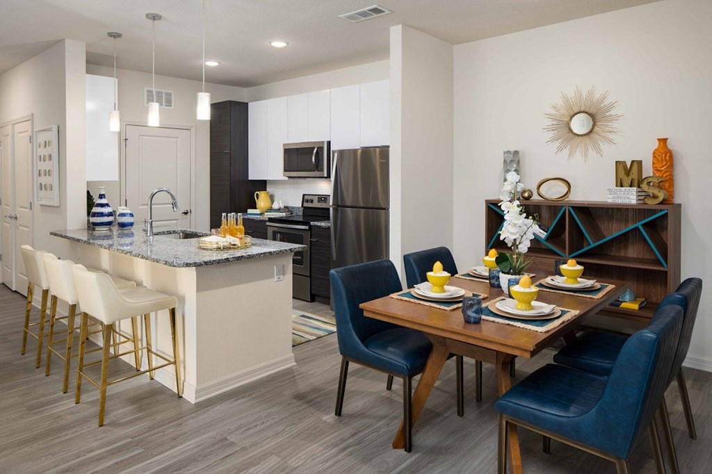 A modern kitchen with a dining table set for two.