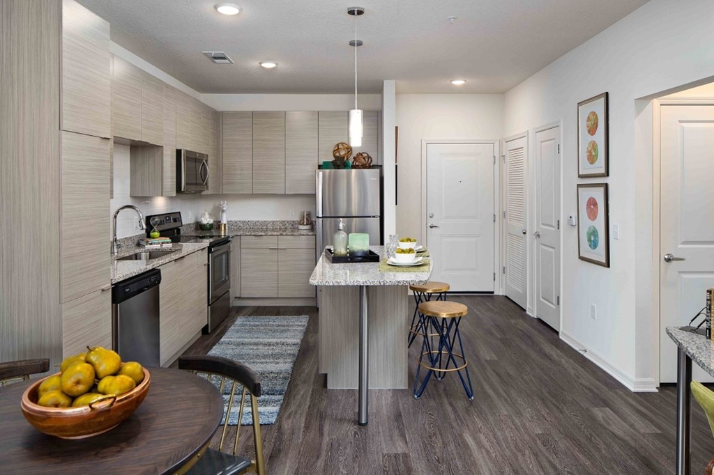 A kitchen with a table and chairs and a bowl of lemons on it.