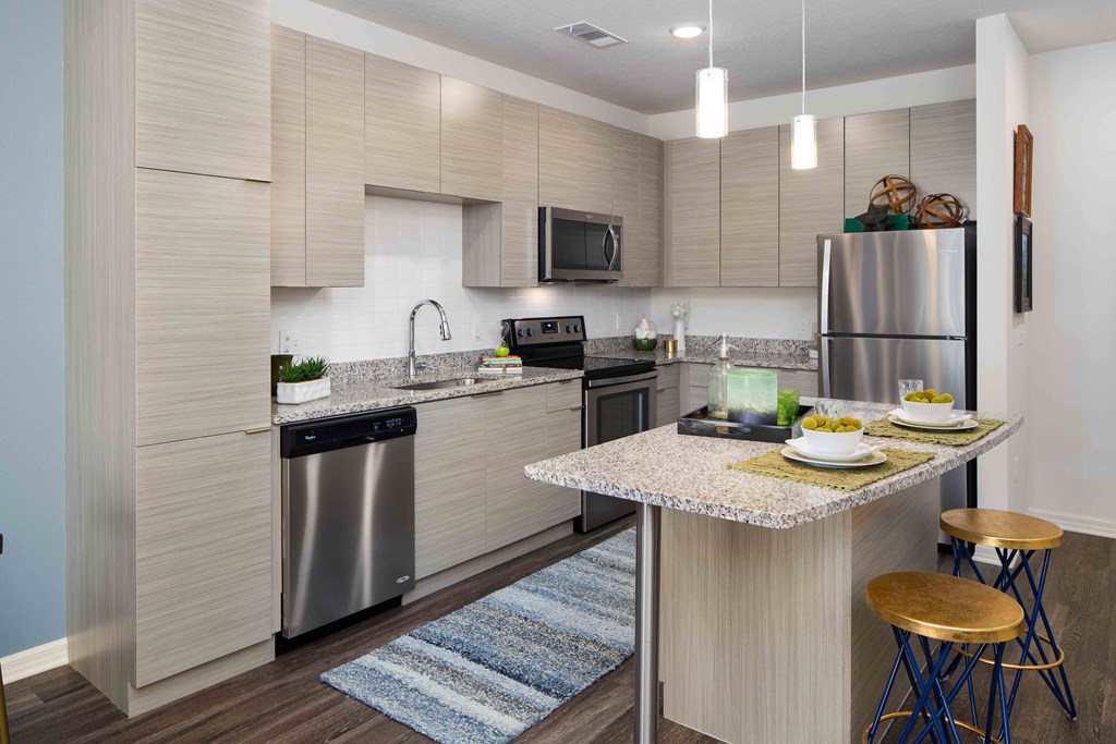 A modern kitchen with a dining table set for two.