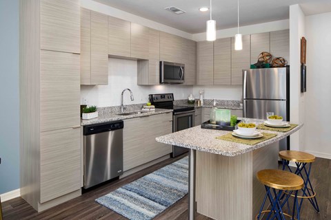 A modern kitchen with a dining table set for two.