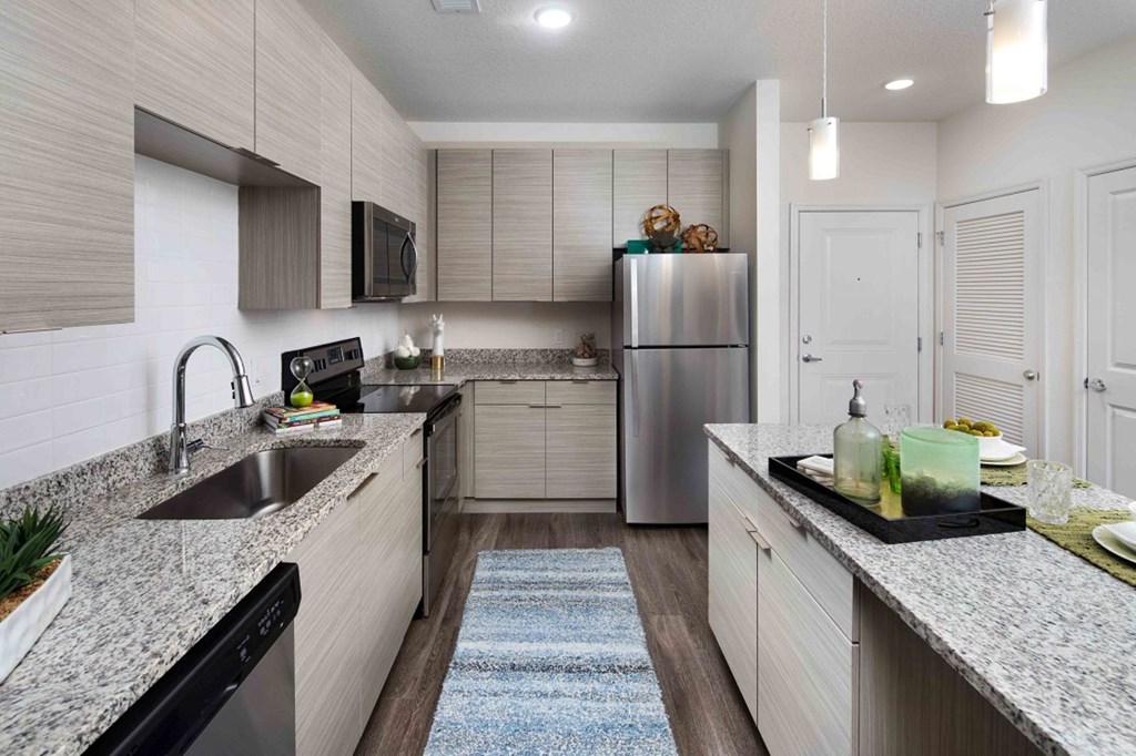 A modern kitchen with a refrigerator, sink, and cabinets.